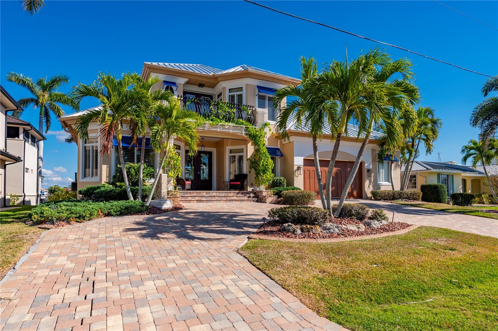 Water defines the experience from the first glance to the final sunset. With swift, DIRECT sailboat access to Charlotte Harbor and the open Gulf beyond, this waterfront residence offers effortless boating paired with a thoughtfully upgraded living environment within the desirable Punta Gorda Isles community. The home features 3 bedrooms, 3.5 baths, and a versatile loft or bonus room in an open, split-bedroom main floor layout that feels both expansive and inviting. Brazilian cherry hardwood floors in the master and loft, a fully refreshed interior, and custom plantation shutters establish a timeless aesthetic, while natural light fills the great room with its volume ceilings, gas fireplace, and expansive sliders opening seamlessly to the lanai. The kitchen blends beauty and function with a five-burner gas cooktop, under-counter wine chiller, generous cabinetry, and a buried 500-gallon propane tank supporting indoor and outdoor features. The primary suite is privately positioned on the main level with direct lanai access, a spacious custom California closet, and a well-appointed bath retreat. Two additional guest bedrooms are also located on the main floor, including one with an en-suite bath and lanai access, offering comfort and privacy for family or visitors. Upstairs, a versatile loft-style space with a convenient half bath opens to a private balcony with elevated water views, making it ideal for a home office, media lounge, or flexible retreat. Outdoor living is a destination of its own, highlighted by a heated pool and spa professionally resurfaced with Pebble Tec in 2024 and enhanced with full automation, waterfalls, fire bowls, and sculptural water features. The screened lanai is designed for effortless entertaining with ambient party lighting, ceiling fan and light combinations, and a fully equipped outdoor kitchen featuring granite countertops, a Coyote grill, dual propane burners, refrigerator, and roof-vented hood. A new walkway leads you down to a concrete dock that was constructed in 2023 providing shore power, fresh water, and exceptional functionality, including two boat lifts replaced in 2023 and rated at 12,000 and 6,000 pounds, along with an additional lift for a kayak or small craft, making quick harbor access (2 minutes to open water) part of everyday life. Additional improvements include two new air conditioning units (installed 2020), a standing-seam metal roof (2023), professional landscaping enhancements in 2024, 2024 Whirlpool, impact-rated doors, Bahama shutters, a motorized front porch sunshade, updated exterior lighting, and an oversized two-car garage with epoxy flooring, custom cabinetry, and extended storage. Dual-zone climate control, multiple water heaters, owned security equipment, and electronic shade and locking systems complete this home, which is shaped by intention, elevated by its setting, and designed for a lifestyle that values both ease and excellence.