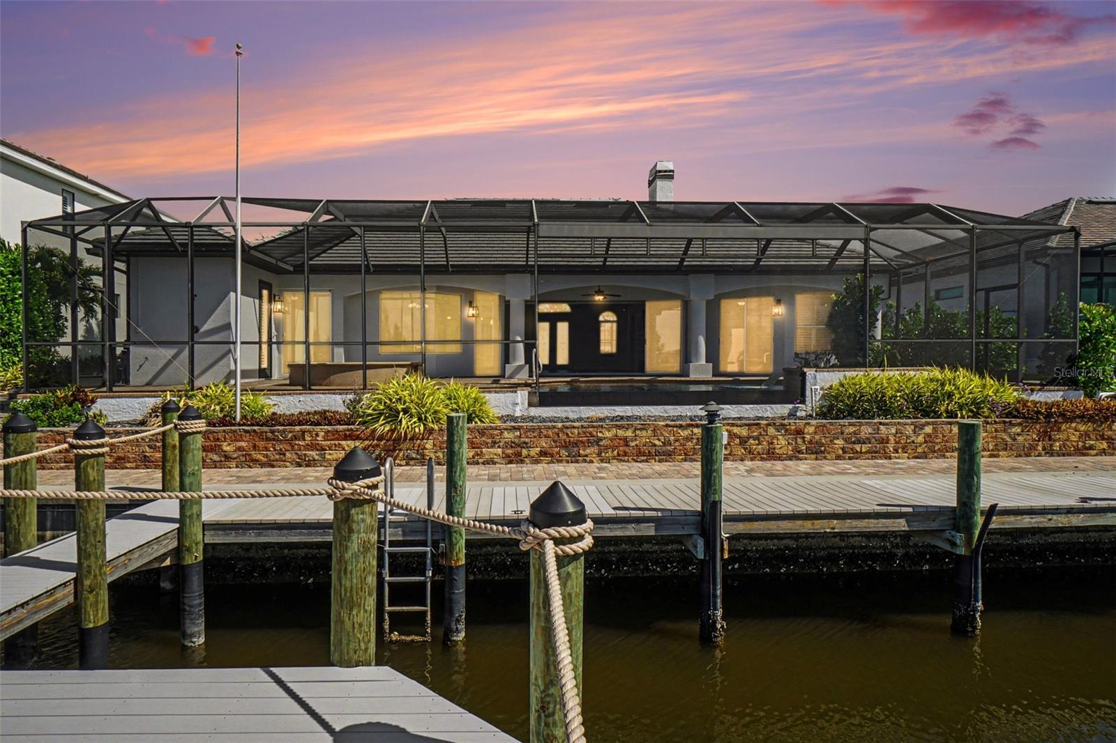 Experience the pinnacle of Southwest Florida waterfront living at 4214 Gulfstream Parkway in Cape Coral. From the moment you enter through the striking double etched French doors, you are immediately captivated by a breathtaking, uninterrupted view that flows through the home, across the stunning infinity-edge pool, and into one of Cape Coral’s largest and widest canals—truly one of the area’s most remarkable waterfront settings. This exceptional concrete block residence offers 2,551 square feet under air and has been meticulously updated and maintained. A 2023 concrete tile roof, installed at a cost exceeding $100,000, while a new central HVAC system installed in 2024 ensures modern comfort. The home has also been freshly repainted inside and out, presenting a crisp, move-in-ready appeal. Designed with both elegance and functionality in mind, the home features a desirable split floor plan with 3 bedrooms and 3 baths. The expansive great room showcases vaulted ceilings with recessed lighting, a gas fireplace, and custom library-style built-ins flanking an impressive wall-mounted television. Pocketing sliding glass doors open fully to blend indoor and outdoor living, maximizing the spectacular water views. Throughout the home, you’ll find refined finishes including plantation shutters, decorative niches adorned with hand-painted Florida murals, and thoughtful architectural details that add warmth and character. The spacious kitchen is a true centerpiece, offering custom cabinetry, upgraded appliances, an eat-in bar, and a bright breakfast nook overlooking the water—perfect for casual dining with a view. Step outside to your private resort oasis where the 60-foot heated infinity pool with saltwater and spa appear to melt seamlessly into the expansive canal beyond. The property is professionally landscaped with a full-yard irrigation system, creating a lush and inviting setting. Boating enthusiasts will appreciate the sea walled frontage, newly re-decked dock, and boat lift—ready for immediate access to Cape Coral’s renowned waterways. Additional features include an oversized 3-car garage with abundant storage and a finished epoxy floor, along with a wide paver driveway and walkway that comfortably accommodates multiple vehicles. Also, A retaining wall was built behind the lanai. The primary suite offers a private retreat with multiple closets featuring California-style built-ins, providing both luxury and organization. The primary bathroom has his and hers sinks, and a walk-through shower. This is a rare opportunity to own a truly distinctive waterfront home where every detail has been carefully curated and every view is unforgettable.