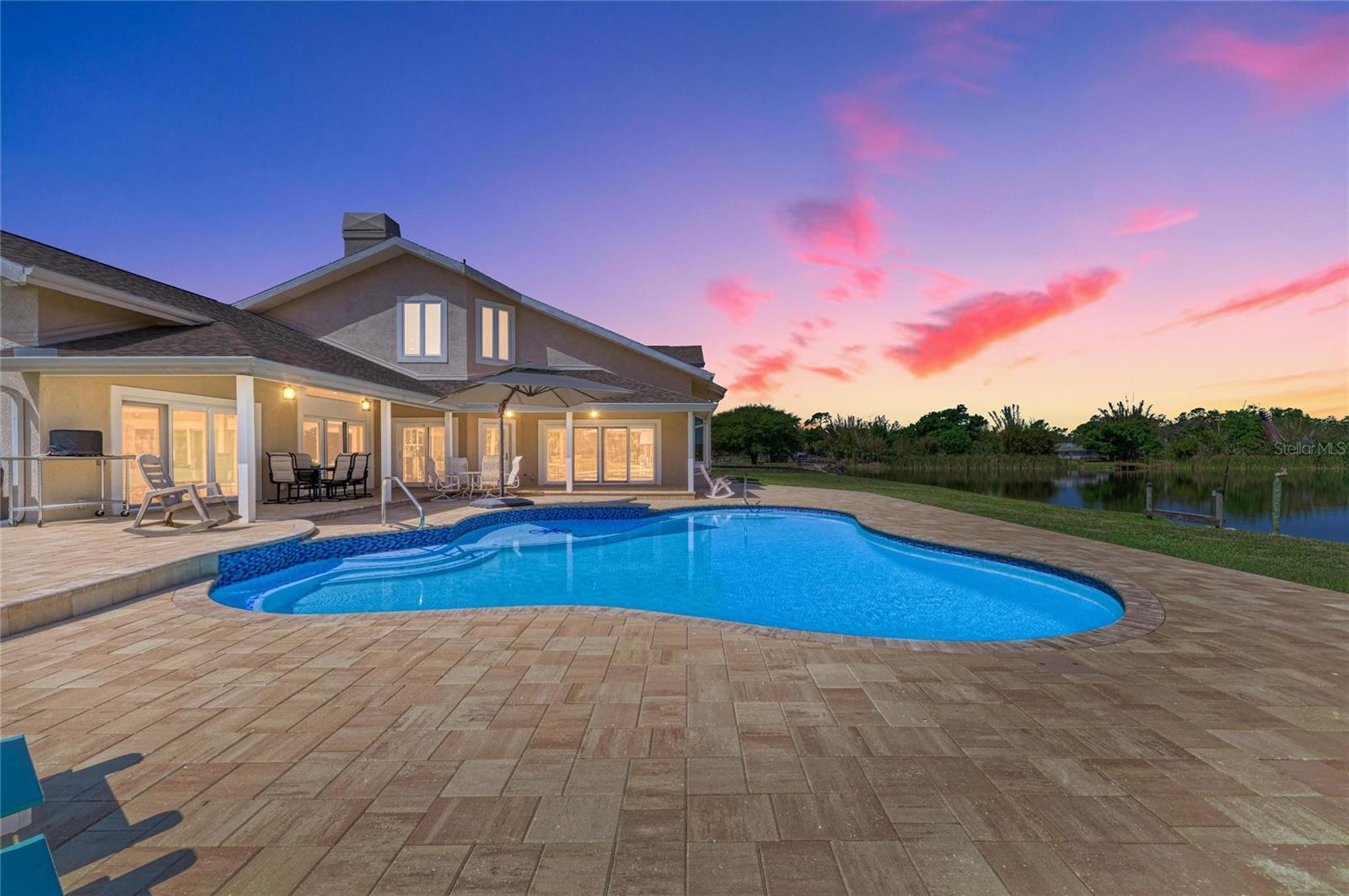 One or more photo(s) has been virtually staged. Stunning Custom Lakefront Estate on 5.86 Acres in Englewood Farm Acres NOT IN FLOOD ZONE

Experience the perfect blend of luxury, privacy, and nature in this custom-designed 5-bedroom, 3-bath estate set on nearly 6 acres, adjoining a 17-acre lake and breathtaking nature preserve. Located in the highly sought-after Englewood Farm Acres, this property offers a rare opportunity to enjoy peaceful country living just minutes from beaches, shopping, and dining.  3 car garage has oversized stalls (longer) and has insulated hurricane garage doors.  The garage is over 950 square feet. 29 x 33 UNDER AIR!!!

A charming courtyard entrance welcomes you into this two-story home featuring soaring whitewashed tongue-and-groove ceilings, rich wood-burning fireplaces, and an open, light-filled floor plan. Expansive windows frame stunning lake and sunset views, while the chef’s kitchen boasts solid wood cabinetry, Corian countertops, a Jenn-Air cooktop, double wall ovens, and a spacious walk-in pantry.

The luxurious primary suite offers a spa-like retreat with a floor-to-ceiling tiled wet-room shower, freestanding soaking tub, quartz vanities, and a large walk-in closet. Additional features include Italian porcelain wood-look tile throughout the main level, solid core doors, smart lighting, and a versatile loft space with hidden storage.

Step outside to your private Florida oasis featuring a newly resurfaced saltwater pool (2025) with sun shelf, LED lighting, and expansive paver deck. Multiple outdoor living areas—including screened, covered, and open-air spaces—provide the perfect setting for entertaining or relaxing while enjoying abundant wildlife, including bald eagles and water birds.

Equestrian and hobby enthusiasts will love the impressive 60x30 two-story barn with 6 horse stalls, workshop space, full utilities, and an air-conditioned upper level. The property is fully fenced with a no-climb fence, includes a private pond, looped driveway with dual gated entry, and is located in a horse-friendly community allowing riding on private roads.

New IMPACT WINDOWS and DOORS(2024), NEW GAF ROOF (2023), metal barn roof, whole-house re-pipe (2023), tankless water heater (2025), and solar power system with battery backup—keeping electric costs minimal. ASK your agent for the complete list of extensive high end updates for this incredible home.
Enjoy direct access to nearby state and county forests, and take advantage of the close proximity to Englewood Beach, Wellen Park, top-rated schools, and medical facilities.

This exceptional property offers the ultimate Florida lifestyle—where modern comfort meets natural beauty.

A Premier Location for the Passionate Equestrian
Ideally situated in the heart of Florida's equestrian corridor, this exceptional property offers the perfect blend of country elegance and coastal convenience. Enjoy easy access to Florida's premier equestrian venues, including Fox Lea Farm (approximately 30 minutes), TerraNova (about 1 hour), and White Fences in Loxahatchee, Global Dressage in Wellington, and the World Equestrian Center—all within an approximate 3-hour drive. Best of all, you're less than 10 minutes from the Gulf beaches, a rare advantage that sets this property apart from most equestrian communities. Experience the unique opportunity to enjoy world-class riding and training while embracing the relaxed coastal lifestyle of Southwest Florida—where your horses and the beach are both within easy reach.