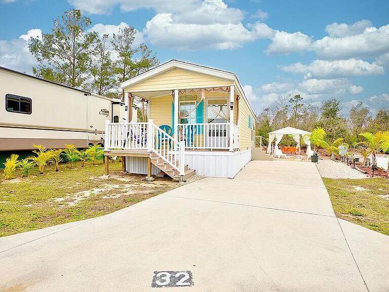 Beautiful  ! Cozy cottage style living in this charming 1-bedroom, 1-bathroom mobile home located at 32 Grassy Lake Cir, Lake Placid, FL. With 511 square feet of living space, this home provides a comfortable and efficient layout. NO LOT RENT! THE LAND IS YOURS ! Set on a 2,400 square foot lot, the property provides ample outdoor space for enjoying the Florida sunshine, along with a front porch and composite decking. The practical design maximizes every inch of space, making it a great choice for those seeking a manageable, low-maintenance lifestyle. Whether you're looking for a year-round residence or a part-time retreat, this property provides the tranquility of Lake Placid living with easy access to surrounding area amenities. Room for a boat, RV, and more. Pergola unit outdoor for shade or hanging out with friends . 
This 2017 model unit was installed in August 2021 and is fully furnished, with stainless steel appliances, full-size furnishings, and all furniture and decorations included. Camp Florida amenities include an Olympic-sized heated swimming pool, tennis courts, and pickleball. Move-in ready needs nothing. NO rental restrictions of any kind in the park .Supermarket , Dollar General right outside the gate. Don’t miss this opportunity only a few homes in the area can accommodate room for boats, RVs or additional parking. This is one !