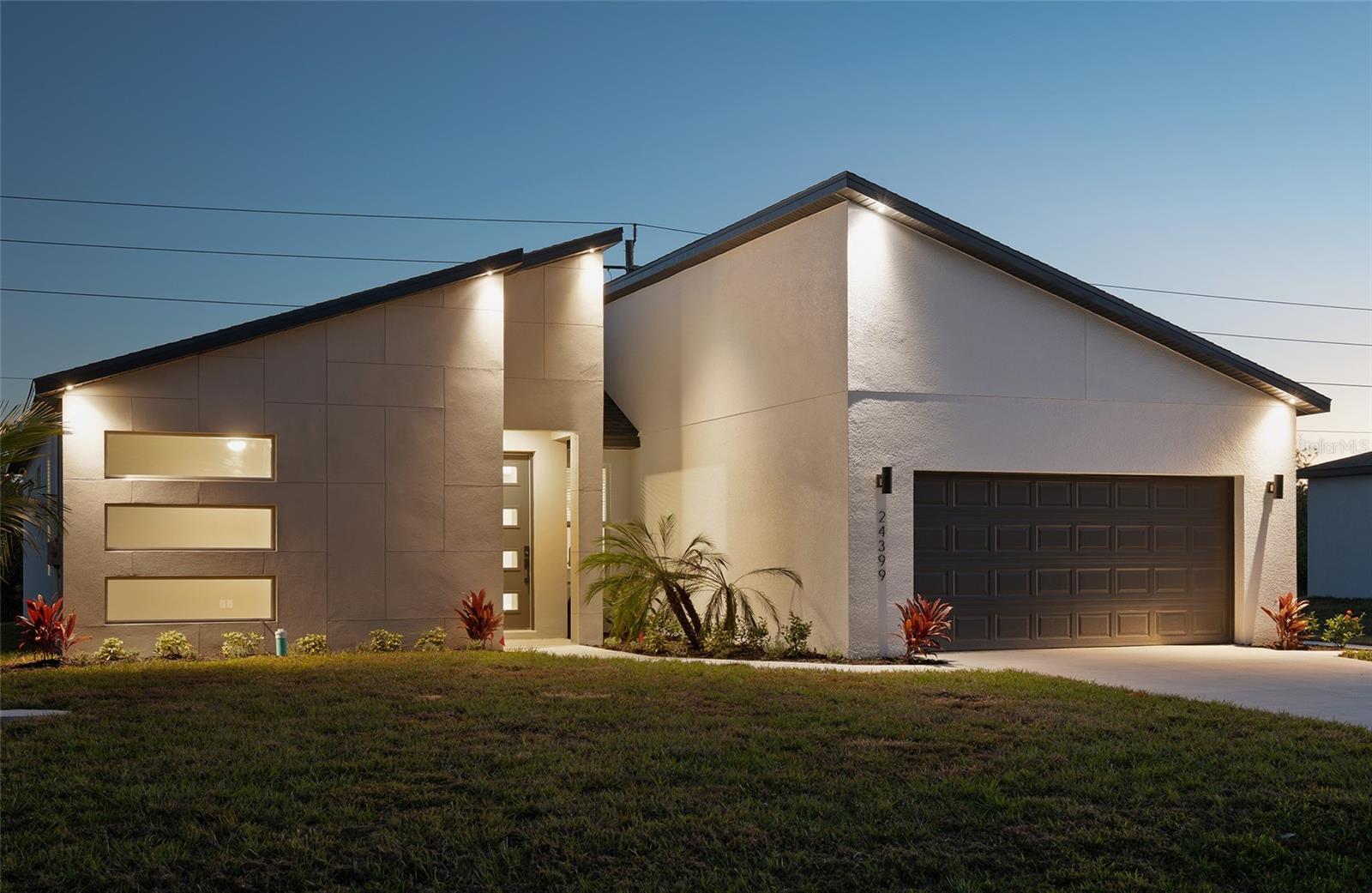 New construction with distinctive contemporary architecture at 24399 SW Kingsway Circle. This four-bedroom, two-bath home offers 1,880 square feet of living space and an attached two-car garage. The open kitchen and living area features a waterfall island, ceiling-height cabinetry with glass-front upper cabinets, stainless steel appliances and pendant lighting. Wood-look tile flooring, tray ceilings and ceiling fans continue throughout the home. The primary suite includes a walk-in closet, dual-sink vanity and a glass-enclosed shower, while the second bathroom offers a tub/shower combination. An interior laundry room, covered front entry and covered rear porch add everyday convenience. Located in The Links near Aileron Golf Club. Never occupied and includes a one-year builder warranty.