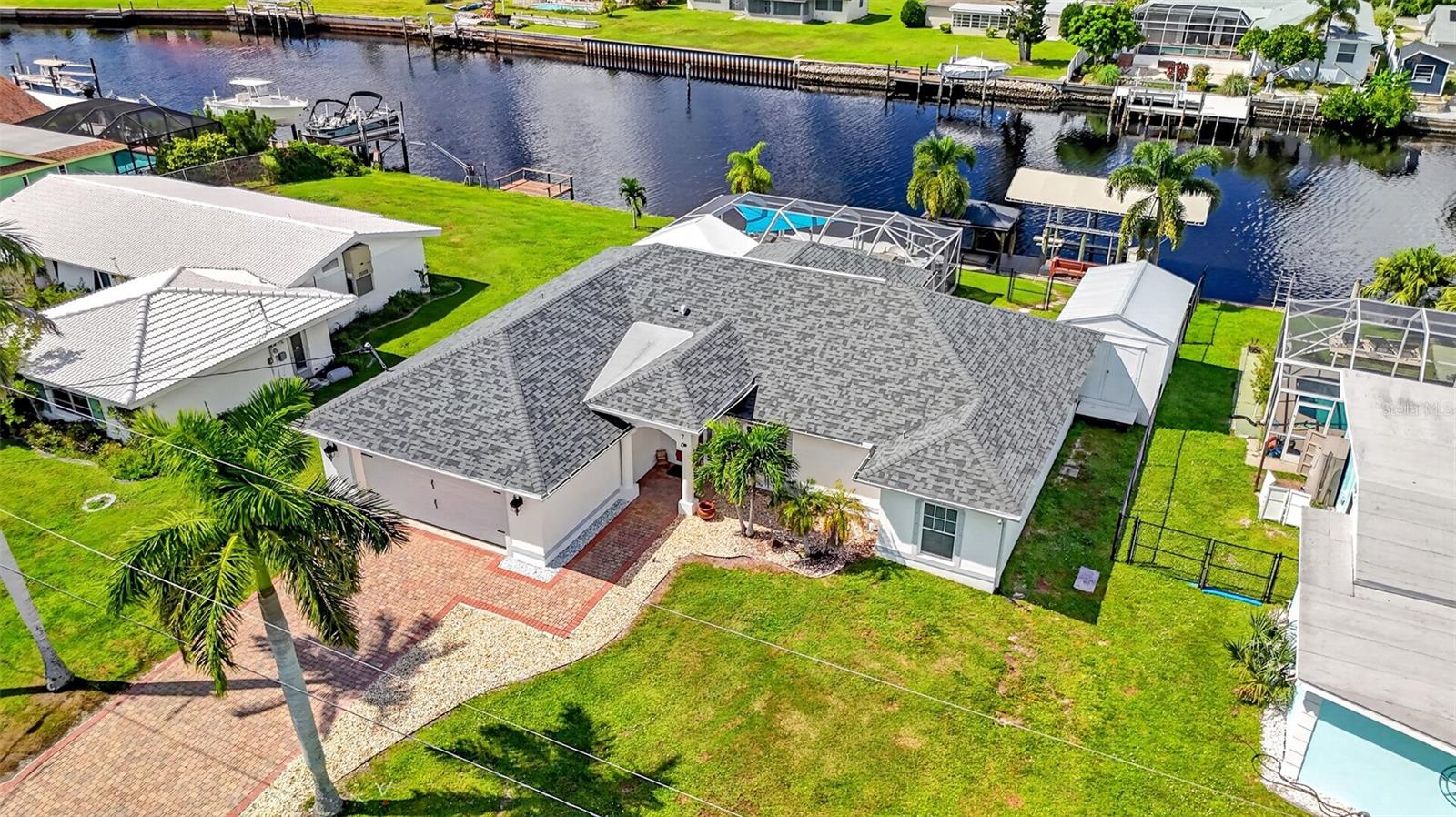 QUICK WATER ACCESS! AMAZING 3 BEDROOM, 3 BATH, 2-CAR GARAGE WATERFRONT POOL HOME IN A POPULAR BOATING SECTION OF PORT CHARLOTTE! Enjoy 80’ of waterfrontage along Tarpon Waterway, with quick powerboat access to Charlotte Harbor and the Gulf. Beautiful curb appeal features a newer roof, paver driveway, and decorative rock landscaping.

Step inside to the living room, where high ceilings, natural light, and neutral tones create a comfortable atmosphere. This space seamlessly connects to the kitchen and dining area, offering an easy flow for everyday living and entertaining. The spacious kitchen features an abundance of cabinetry, granite countertops and backsplash, new LED light fixtures, stainless-steel appliances, a closet pantry, and breakfast bar.

The generous primary suite features a tray ceiling, water views, and a large walk-in closet, along with an updated ensuite bath featuring dual sinks, a garden tub, a walk-in tile shower, and a private water closet. The two guest bedrooms offer comfortable accommodations, with one featuring a private ensuite bath, plus a second full guest bath.

Enjoy your own private outdoor retreat, featuring a covered and screened lanai with paver decking, a swimming pool, and a raised spa. The spacious outdoor area offers plenty of room for outdoor dining, lounging, and entertaining, creating a great setting to enjoy the Florida lifestyle. Beyond the screened pool area, an additional paver patio provides extra outdoor space, while the detached outbuilding features a window A/C unit and is currently set up as a home gym.

The waterfront is a standout feature of this property, with a dock featuring Trex decking, a 10,000-lb. boat lift, 20,000-lb. beams allowing for a potential upgrade to a larger lift complete with water and electric. An additional floating dock offers space for a jet ski or small boat. A stepping-stone walkway leads through the backyard to the dock, where a covered seating area provides the perfect spot to cast a fishing line, relax, and take in the waterfront views.

Additional highlights include a newer boat canopy, a new patio on the right side of the backyard, a new pool pump, and two ensuite baths.

Enjoy a great location with convenient access to Charlotte Harbor, Sunseeker Resort, and the Murdock shopping and restaurant district, along with nearby parks, golf, boating, and fishing. Port Charlotte Beach Park is also accessible by boat or kayak, offering a fun destination for swimming and enjoying time on the water. Improvements to the park's recreation center and pool add to the area's recreational appeal. Historic downtown Punta Gorda is also nearby, featuring waterfront dining, arts, community events, and entertainment.

Don't miss this opportunity! Call to schedule your private showing today!