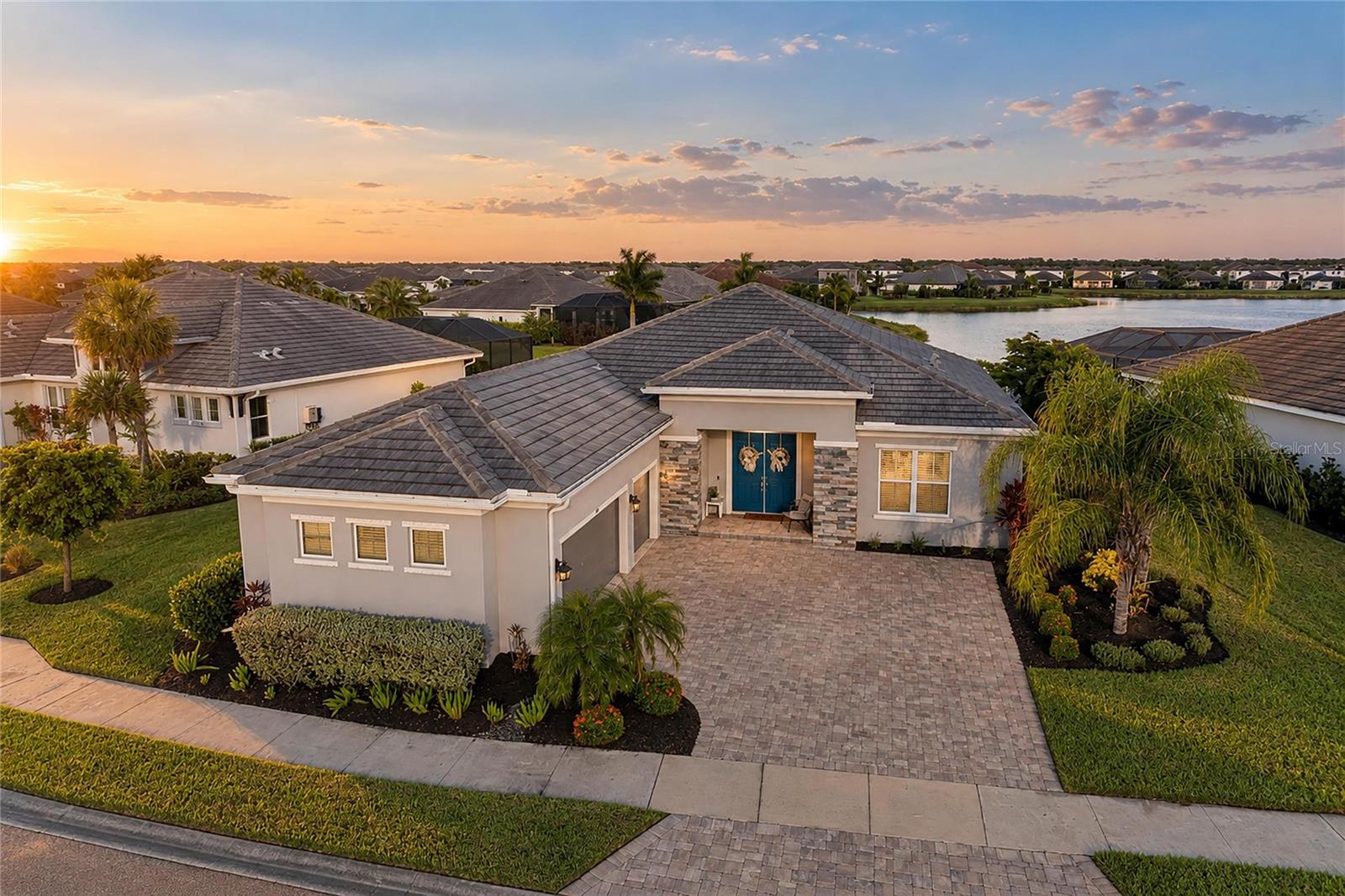STUNNING WATERFRONT LIVING, EXCEPTIONAL DESIGN & SPECTACULAR OUTDOOR LIVING! Immaculately maintained and used only as a part-time residence, this magnificent Cardel, built home offers the look and feel of new construction. Situated on an expansive homesite of over 1/4 of an acre in the gated community of Worthington. From the moment you enter through the double doors, captivating water views create an unforgettable first impression and the well-designed designed floor plan features four distinct areas, offering privacy and flexibility, with a tucked away spacious waterfront owner’s suite featuring two closets and a elegant bathroom with gorgeous floor-to-ceiling shower tile, dual vanities and a private water closet. A dedicated den with double glass doors overlooks the front of the home, while two additional bedrooms share a beautifully appointed bathroom. A separate flex room offers endless possibilities of adding a 4th bedroom, with an adjacent third bathroom that doubles as a convenient pool bath with direct outdoor access. At the heart of the home, the gorgeous gourmet kitchen showcases a premium suite of KitchenAid appliances, beautiful cabinetry with a carved wood hood and crown molding, soft-close drawers, stylish hardware and refined finishes. The dining room features a unique set of sliding glass doors opening to the pool area, with three additional sets of sliders in the living room creating a seamless connection to the spectacular outdoor living space. Elegant travertine decking surrounds the heated saltwater pool and stunning flush-level spa, all overlooking tranquil water views. The pool and spa feature natural gas heating, a solar pool cover, premium Pentair equipment with convenient ScreenLogic smart controls, and vibrant ColorBrite LED lighting, including two lights in the pool, one in the spa, and one on the sun deck. An expansive covered lanai and generous space for outdoor dining, entertaining, and relaxation. The desirable eastern exposure welcomes beautiful morning sunrises across the water, while the covered lanai provides a comfortable retreat throughout the day. Additional enhancements include a recently redesigned laundry room, featuring custom cabinetry and rich dark walnut butcher-block countertops, creating a functional drop zone and generous folding space. Newer gutters, a whole-home water softener system, integrated soffit exterior lighting and modern chandeliers throughout, storm protection for all windows and smart-home features. The impressive side-entry three-car garage features an attractive paver driveway, epoxy flooring, overhead storage racks and windows welcoming natural light. Built by award-winning Cardel Homes, known for its distinctive designs and attention to detail, this residence reflects quality craftsmanship throughout. Worthington offers a convenient Sarasota location near I-75, Celery Fields, parks, shopping and dining, yet remains tucked away from the everyday bustle. LOW HOA FEES AND NO CDD FEES add to the appeal of this exceptional property. Select furnishings may be available by separate agreement. A remarkable waterfront residence that truly deserves to be experienced in person!