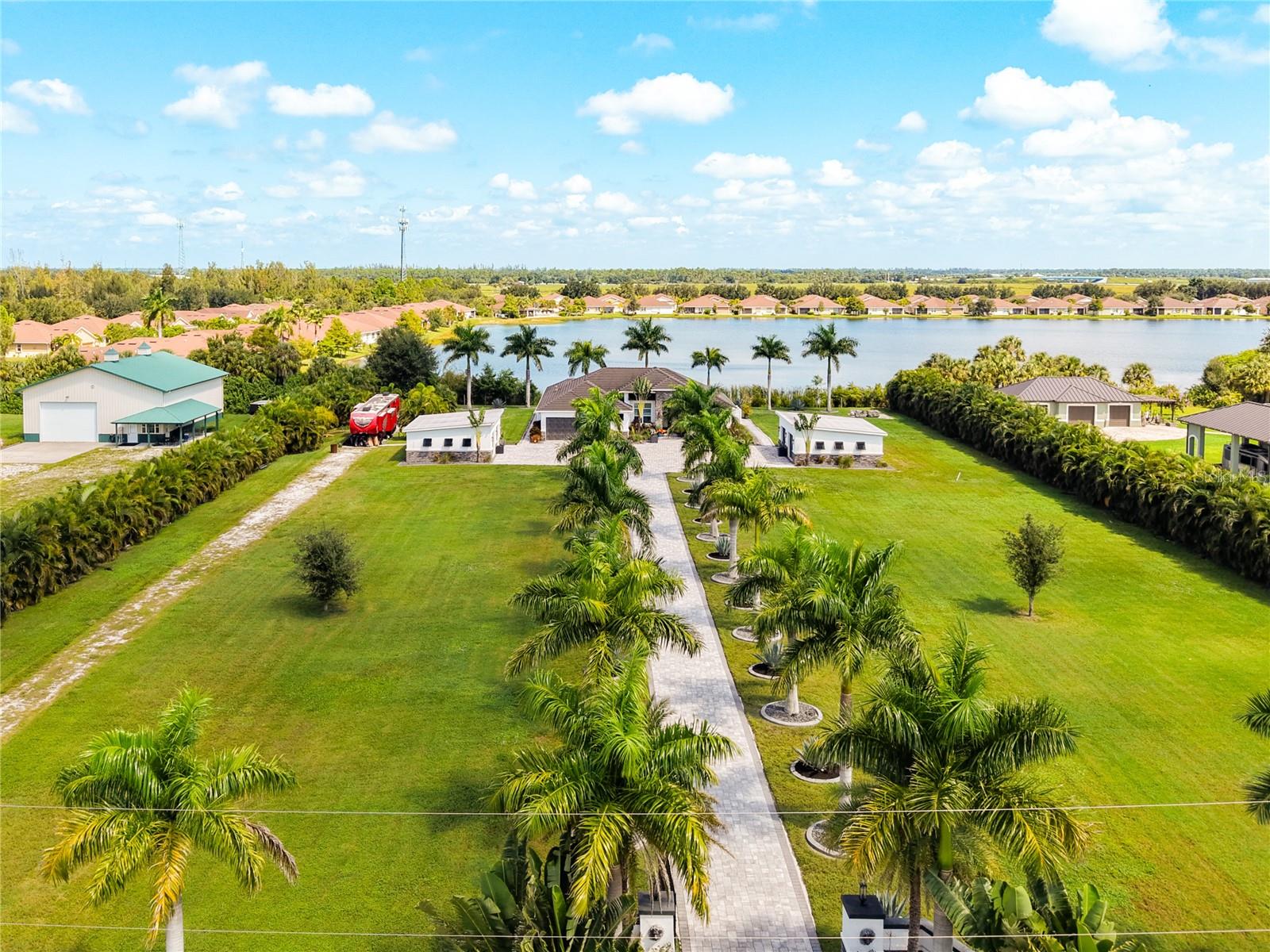 YOUR DREAM HOME IS HERE! Imagine coming home to 2.37 fully fenced acres where privacy, resort-style outdoor living, and modern design come together in one unforgettable property. Built in 2019 and conveniently located near I-75 and Punta Gorda, this impressive residence offers 2,882 square feet under air, mature palm trees, and plenty of open space to enjoy.

Inside, the bright open floor plan welcomes you with tray ceilings, recessed lighting, and a spacious living area centered around an electric fireplace. The kitchen is designed to stand out, featuring quartz countertops, soft-close cabinetry, upgraded appliances, and abundant space for cooking and gathering. A media room or playroom, dedicated office, and utility room with a sink provide the flexibility needed for work, entertainment, and everyday life.

The primary suite is a true retreat with tray ceilings, two walk-in closets, and a spa-inspired bathroom featuring dual vanities, quartz countertops and a dual-entry walk-in shower. The spacious secondary bedrooms are complemented by a conveniently located pool bath with a walk-in shower.

The outdoor area is where this home truly comes alive. A 30' x 12' covered patio features a built-in bar, TV, ceiling fans, and an indoor/outdoor speaker system, creating the perfect setting for entertaining. The saltwater pool and spa include upgraded lighting, automation, and a clear-view screen enclosure for unobstructed views of the surrounding property.

Impact-resistant windows, a concrete tile roof, three-zone A/C, and spray-foam insulation in both the home and detached garage add comfort and efficiency. Additional features include city water, a septic system, a separate irrigation well, a 21-zone irrigation system, a powered courtyard, a detached garage with electricity, extensive pavers, and upgraded lighting and fixtures throughout.
 Schedule your private showing and experience it for yourself!
