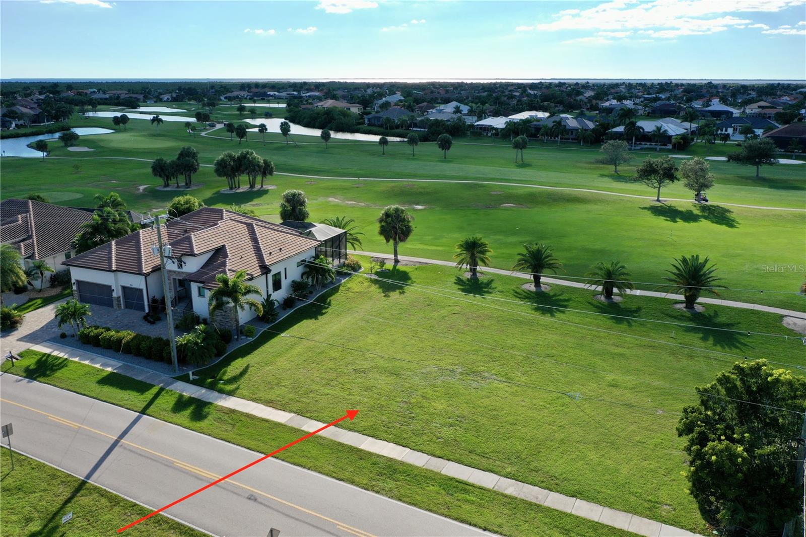 Sunsets over the fairway out back, a long canal view across the street out front. That is the rare double exposure waiting at 3501 Bal Harbor Blvd, an oversized .28 acre homesite sitting directly on the 9th hole of St. Andrews South Golf Club in the heart of Punta Gorda Isles.

Measuring 100' x 120', this parcel carries 100 feet of road frontage and a matching 100 feet along the golf course, with 120 feet of depth for 12,124 square feet of usable land. That 100-foot width is the detail builders will notice immediately. Most lots in the Isles run 80 feet wide, so you have a full 20 extra feet to work with, enough to stretch a wide-open floor plan, add a 3-4 car garage, or set a generous pool and lanai across the back without crowding your setbacks. The western-facing rear exposure means your lanai looks straight down the fairway into the evening sky.

The lot is completely cleared and regularly mowed, a true ready-to-build canvas with CITY WATER & SEWER available. Located in one of Punta Gorda’s most established communities of Punta Gorda Isles, where mature landscaping and well-kept homes have set the standard for decades.

Its size and zoning accommodate a single-family estate home, a villa design, or up to four multi-family units. That flexibility is genuinely rare in Punta Gorda Isles. 

Golfers, you are already home. St. Andrews South is a member-owned club with optional memberships, so you can walk out your back door and play. Boaters are minutes from Ponce de Leon Park at the western edge of the city, a 16-acre waterfront park on Charlotte Harbor with a boat ramp and trailer parking, fishing piers, a sandy beach, a quarter-mile wetland boardwalk, and the Peace River Wildlife Center. It is the spot locals claim for sunsets, and watching the boats run the channel back into the PGI canal system.

Everything else is close. Historic downtown Punta Gorda is about 5 minutes away, with brick-lined streets, boutique shopping, the weekly farmers market, art galleries, and waterfront dining. Fishermen’s Village brings harborside restaurants, shops, and seasonal festivals. Nearby you will also find medical care, waterfront parks, miles of bike paths, and Charlotte Harbor itself, one of the finest fishing and cruising estuaries in the state. Interstate 75 and Punta Gorda Airport are both an easy drive, making regional travel and arriving guests simple.

One hundred feet of golf course frontage, water views across the way, cleared and utility-ready, and zoning that lets you decide what gets built. Lots with this combination do not come back around. Don't miss your opportunity today!