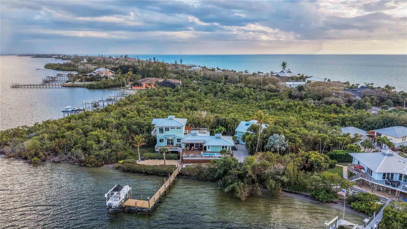 Welcome to 7885 Manasota Key Road, a rare waterfront estate offering panoramic water views, private beach access, and exceptional flexibility for multigenerational living or investment opportunities. Situated on more than two combined acres on beautiful Manasota Key, this extraordinary property delivers the space, privacy, and coastal lifestyle that is rarely available on Florida’s Gulf Coast. The main residence captures breathtaking panoramic views of the water and surrounding natural landscape, creating a stunning backdrop from the primary living areas. Large impact windows and open living spaces invite natural light throughout the home and provide the perfect setting for relaxing, entertaining, or simply enjoying the peaceful waterfront surroundings.  What makes this property truly unique is the presence of three separate residential improvements on the property. In addition to the main home, two guest houses provide additional living space that is ideal for extended family, guests, or creating income producing rental opportunities.  Outdoor living is designed for enjoying the Florida lifestyle. A private swimming pool provides the perfect place to relax after a day on the water or at the beach, while the outdoor fire pit creates a beautiful setting for evening gatherings and sunset views.  Boating enthusiasts will appreciate the private boat dock which provides convenient access to the surrounding waterways. The property also includes deeded private beach access to the Gulf of Mexico, allowing owners and guests to easily enjoy the white sand beaches and spectacular sunsets that make Manasota Key so desirable.  A spacious four car garage provides ample room for vehicles, recreational equipment, water toys, and additional storage.  This exceptional property offers outstanding flexibility for a variety of uses including a private coastal estate, multigenerational family compound, seasonal retreat, or income producing investment. Both short term and long term rentals are allowed, creating significant potential for those looking to generate rental income while enjoying the property.  Located on one of Southwest Florida’s most sought after barrier islands, 7885 Manasota Key Road offers a rare opportunity to own a waterfront estate with land, privacy, and multiple residences in a setting that captures the true essence of coastal living.