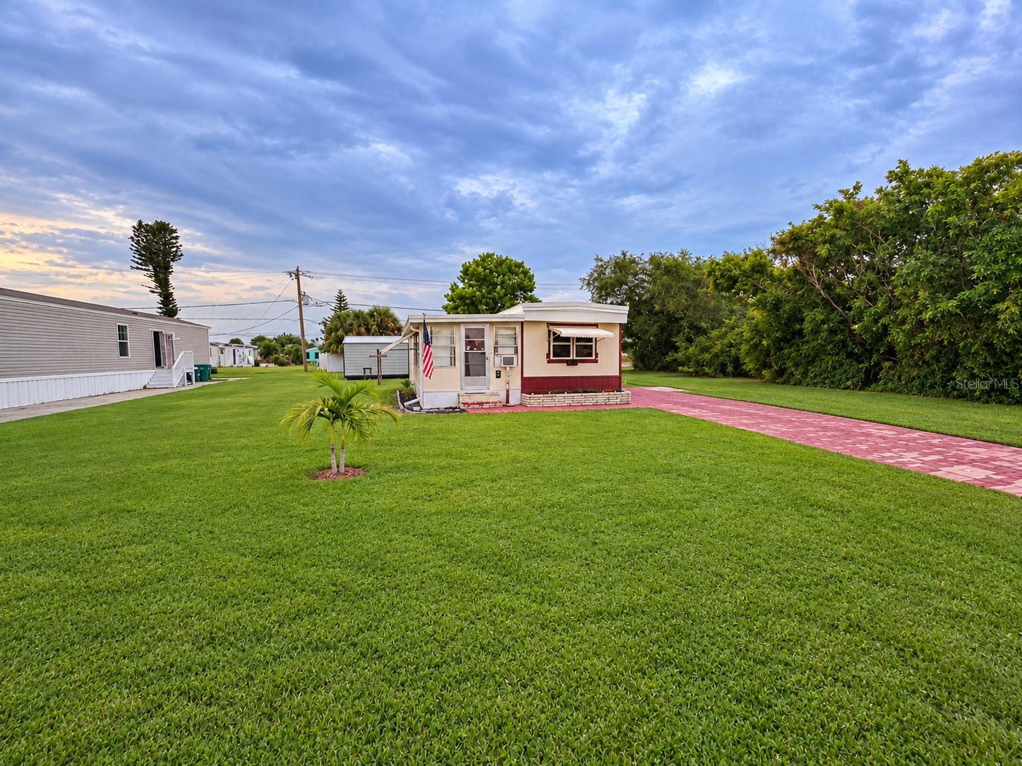Virtually Staged. OWN THE LAND AND START ENJOYING THE ENGLEWOOD LIFESTYLE! Welcome to 1394 Flamingo Drive, located in the 55+ Manatee Cove community, formerly Holiday Mobile Estates. This affordable Englewood retreat offers something increasingly hard to find—land ownership.
Step inside and discover a surprisingly comfortable 2-bedroom, 1½-bath home with approximately 812 square feet of total living space. The kitchen has been remodeled with updated cabinetry and 2023 appliances, including an LG refrigerator, cooktop and microwave. Additional improvements include an updated primary bath, built-in washer and dryer, laminate flooring, newer roof and newer A/C. A 12' × 14' rear shed provides valuable additional storage. Outside, the generous approximately 7,800-square-foot homesite provides plenty of room to enjoy Florida's year-round outdoor lifestyle without the cramped feeling found in many manufactured-home communities. Florida Parcels
And the location is pure Englewood. Spend the day boating, fishing, enjoying the Gulf beaches, exploring Old Englewood and Dearborn Street, or taking advantage of nearby recreation. The area offers excellent public amenities, including Ann & Chuck Dever Regional Park with recreation, aquatic facilities and nature trails. Whether you're searching for a seasonal Florida escape or an easy-to-maintain year-round residence, 1394 Flamingo offers an outstanding opportunity to own your piece of paradise without paying lot rent. Bring your flip-flops, fishing poles and Florida dreams—this one is ready for its next owner!