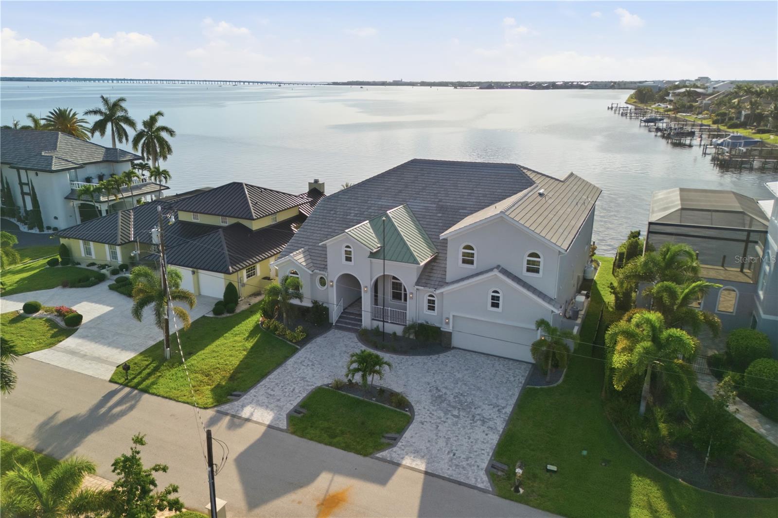 Welcome to an extraordinary waterfront residence where timeless design, exceptional craftsmanship, and the coveted Punta Gorda lifestyle come together. Built in 2024 by West Coast Builders, this custom home offers nearly 4,400 square feet under air (4,393 sq. ft.) and has been thoughtfully designed to maximize comfort, elegance, and breathtaking harbor views.
Perfectly positioned on 80 feet of direct Charlotte Harbor frontage, this sailboat-access property offers no bridges to open water, making it a dream location for avid boaters and anglers alike. From your backyard, set out for world-class fishing, leisurely cruises, waterfront dining, or adventures into the Charlotte Harbor and beyond to the Gulf of America.
Inside, every detail reflects quality and sophistication. All three generously sized bedrooms feature private en-suite baths, providing comfort and privacy for family and guests. The upper-level primary retreat is a sanctuary of its own, complete with an expansive walk-in closet, elevator access, and a spacious private balcony where panoramic views of the harbor and the charming skyline of Punta Gorda create the perfect backdrop for morning coffee or spectacular sunrises.
The oversized two-car garage boasts extra-high ceilings that may possibly accommodate a vehicle lift, offering flexibility for collectors or hobbyists. Throughout the home, luxury finishes, storm-rated windows, and roll-down hurricane protection provide both beauty and peace of mind.
Life here extends far beyond the property lines. Residents enjoy the renowned boating culture, vibrant downtown restaurants and shops, waterfront parks, pickleball and tennis facilities, and numerous nearby golf courses that have made Punta Gorda Isles one of Southwest Florida’s most sought-after waterfront communities.
This is more than a home—it's an invitation to embrace an exceptional coastal lifestyle where every day begins and ends with the beauty of the harbor.