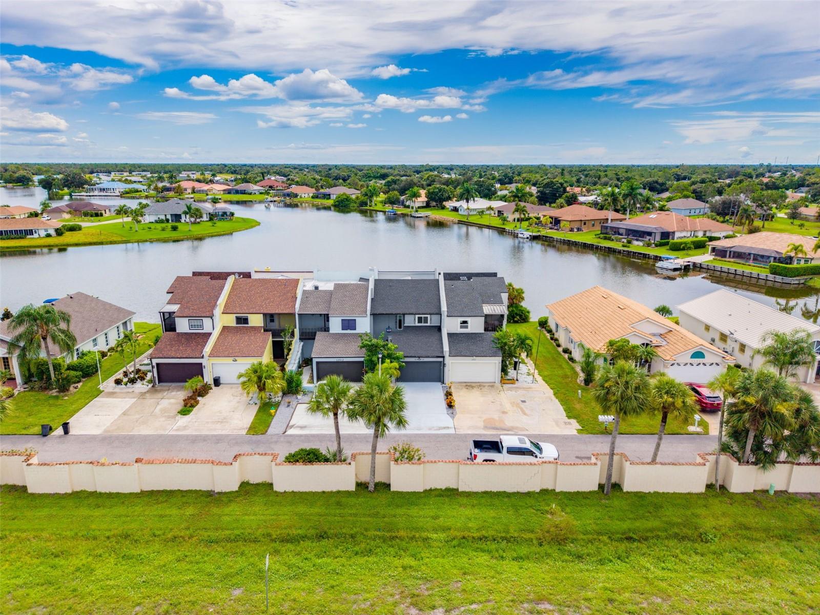 ONE-OF-A-KIND DESIGNER LAKEFRONT RESIDENCE WITH NO HOA, BREATHTAKING SUNRISES, PANORAMIC WATER VIEWS AND AN EXTRAORDINARY LEVEL OF CUSTOMIZATION THROUGHOUT! Designed and curated by an interior designer with 30 years of experience with over $380,000 invested, this spectacular 3-bedroom, 2.5-bath waterfront home offers over 2,400 square feet of living space where virtually every room has been thoughtfully transformed with distinctive finishes, custom details and upgrades you simply will not find in an ordinary home. From the moment you enter, the attention to detail is undeniable. The showpiece kitchen features an oversized quartz island with extensive seating, custom cabinetry with illuminated glass displays, premium appliances, induction cooking, designer range hood, pot filler, built-in refrigeration, beverage station and incredible storage, all opening seamlessly into the dining and living areas. At the center of the home is a truly unique floor-to-ceiling glass atrium filled with lush tropical landscaping, bringing natural light and greenery directly into the living space and creating an indoor/outdoor atmosphere unlike anything else on the market. The expansive living room is designed around the WATER VIEWS and features custom built-ins, an impressive fireplace/entertainment wall and large sliders opening to the screened waterfront lanai. Step outside and embrace the Lake Suzy lifestyle, where the expansive freshwater lake allows boating right from your backyard—perfect for leisurely sunset cruises, peaceful days on the water, and fishing just steps from home. Upstairs, the primary suite is a destination of its own with expansive lake views, private outdoor living, a spectacular spa-inspired bathroom with dual vanities and an oversized custom shower, plus an incredible boutique-style walk-in closet with extensive built-in cabinetry and display storage. Two additional bedrooms and a beautifully updated guest bath provide plenty of room for family and visitors. Outdoor living is equally impressive with multiple screened and covered spaces overlooking Lake Suzy and a massive custom metal waterfront dock providing an incredible place to relax, entertain and take in the peaceful surroundings. Wake up to GORGEOUS SUNRISES shimmering across the lake and enjoy wide, unobstructed water views from multiple areas of the home. Major improvements include a NEW ROOF IN 2022, TWO A/C SYSTEMS, updated electrical, smart energy-efficient water heater and approximately $80,000 invested in ENERGY EFFICIENT IMPACT WINDOWS AND SLIDERS. SMART HOME TECHNOLOGY provides convenient control of lighting, climate and other features throughout the residence. Additional details include designer lighting, custom wall treatments, upgraded flooring, barn doors, extensive built-in cabinetry, multiple outdoor living areas, attached 2-car garage and countless custom touches that must be seen in person to fully appreciate. AND PERHAPS MOST IMPRESSIVE—NO HOA FEES! Enjoy the waterfront lifestyle and single-family-style living without the monthly association expense normally expected in a property like this. Located in beautiful Lake Suzy with nearby golf, shopping, dining and convenient access to I-75, this is not a cookie-cutter Florida home—it is a PERSONALIZED WORK OF DESIGN overlooking the water. IF YOU HAVE BEEN WAITING FOR SOMETHING TRULY DIFFERENT, THIS IS IT—SCHEDULE YOUR PRIVATE SHOWING TODAY AND EXPERIENCE THIS REMARKABLE LAKEFRONT HOME FOR YOURSELF!