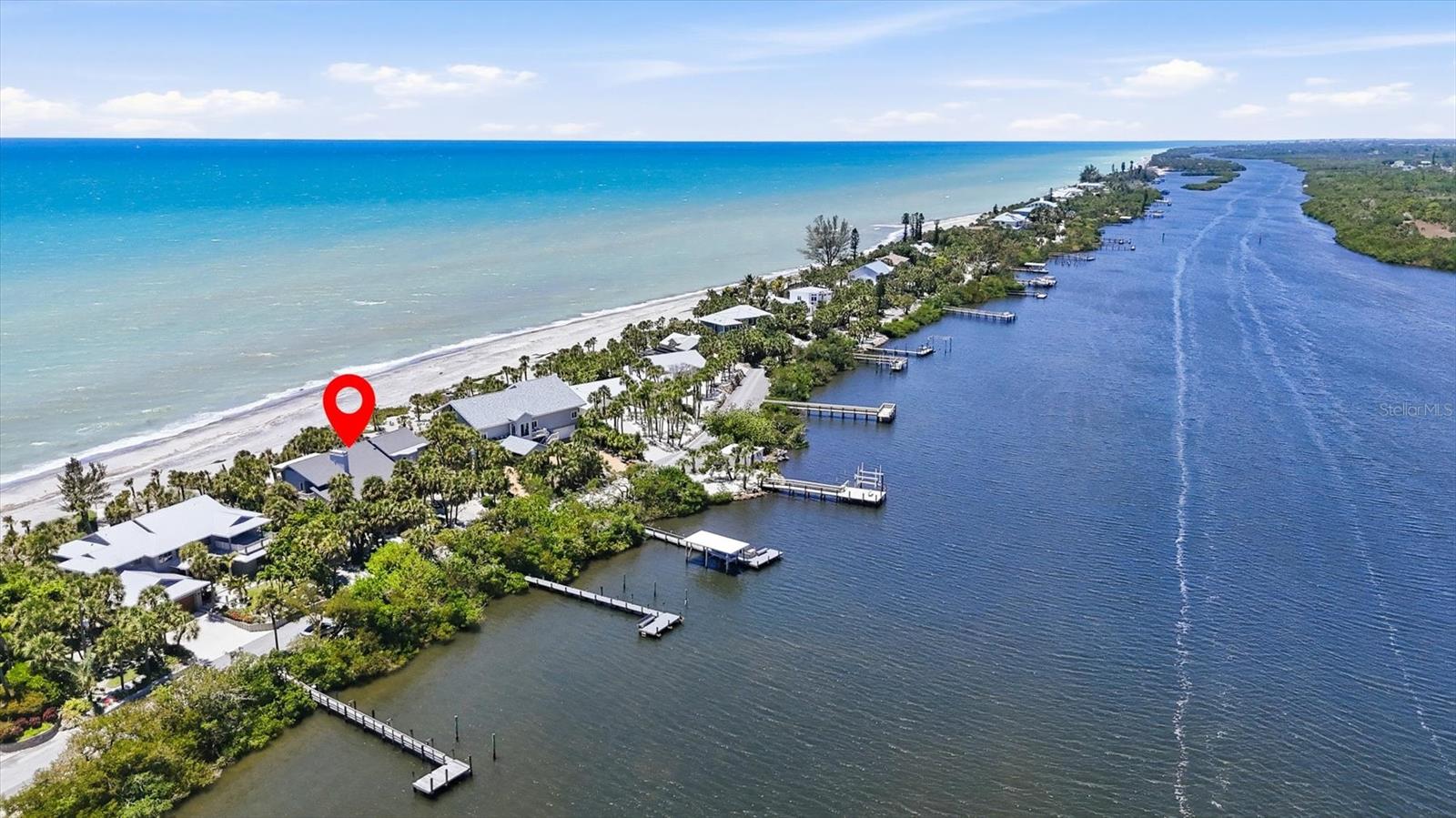 Positioned on the coveted north end of Manasota Key, this extraordinary Gulf-to-Bay estate offers nearly an acre of private coastal living with approximately 100 feet of direct Gulf frontage and serene bay access along Lemon Bay. Designed to capture sweeping water views and effortless elegance, the residence features four spacious bedrooms—all with walk-in closets—and four full baths, including two luxurious upper-level primary suites overlooking the Gulf. The main living areas showcase soaring cedar ceilings, travertine flooring, a wood-burning fireplace, and an expanded living room that frames breathtaking sunsets. A chef’s kitchen anchors the home with a gas range and hood, Sub-Zero refrigerator, double convection ovens, granite surfaces, and an oversized island ideal for entertaining. Thoughtfully designed for flexibility, the layout includes a first-floor den with private bath, a second-floor office with French doors and Gulf views, and a generous bonus/family room. Modern upgrades include full hurricane protection, three new A/C systems (2025), a buried propane tank, and two refrigerated wine closets. Outdoors, Ipe decking surrounds the home, while a newly constructed composite dock (2026) on the bay side is plumbed for water—perfect for embracing the ultimate waterfront lifestyle. Located within a gated enclave along a private two-mile road, this beachfront sanctuary offers rare seclusion just moments from dining, marinas, and golf, delivering an unparalleled blend of tranquility, sophistication, and refined coastal living.