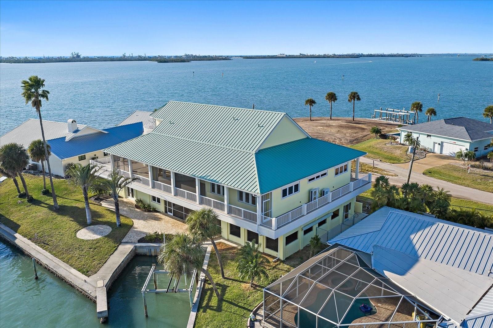 Virtually Staged. A masterwork of coastal positioning, this landmark waterfront estate represents one of the most commanding geographical opportunities on Lemon Bay. This one-of-a-kind sanctuary is surrounded by water in nearly every direction, offering an unrepeatable 107 feet of bay frontage.

Substantially reimagined and expanded in 2006—with the second and third levels custom-constructed—this elevated multi-level coastal estate has had all of the major capital improvements completed. Recent high-value investments include a brand-new metal roof (April 2024), full interior and exterior paint (Nov 2024), three high-efficiency HVAC systems (2023), a dedicated pool heat pump (April 2020), whole-house water filtration and softening, updated electrical infrastructure, and full hurricane impact windows and doors paired with additional shutter protection for total structural peace of mind.

For the yachting enthusiast or discerning land collector, the property features a massive seawall and immediate sailboat-water access with no fixed bridges to the open Gulf via Stump Pass. Strategic re-engineering options for the expansive seawall allow for vessels ranging from 50 to 100 feet, making it a rare sanctuary for elite maritime craft.

Spanning an impressive 4,937 sq ft under air across a meticulously designed layout, this 5-bedroom, 4.5-bathroom estate effortlessly frames sweeping, panoramic water views from nearly every room. An internal elevator seamlessly services every level, from the ground floor up to the third-story observation suite.

The main living level features soaring 10- and 12-foot ceilings, a gas fireplace framed by rich travertine, and extensive custom built-ins. Flowing effortlessly into the dining area, the gourmet culinary space is appointed with custom cherry wood cabinetry, solid-core wood doors, premium granite countertops, a large entertaining island, a Thermador gas range, and a brand-new GE stainless refrigerator.

Four bedrooms are situated on the main level, including two comprehensive en-suites. The primary suite serves as an exquisite private oasis, complete with French door balcony access, a custom walk-in closet, and a spa-like bath with dual showerheads.

Ascend via elevator to the top floor, which functions as an elite observation retreat or bonus entertainment lounge. Outfitted with a wet bar, wine storage, and refrigeration, French doors open out to a private wraparound balcony offering bird’s-eye views across the Intracoastal, canal, and distant Gulf horizon.

Providing unmatched flexibility for multi-generational living or an executive retreat, the ground level serves as a private, fully air-conditioned mother-in-law suite (featuring 729 sq ft of non-conforming space). Designed with its own private entrance that can be completely separated from the main residence, it includes a dedicated living area, bedroom, and full bath that opens directly to the resort-style screened pool and spa with premium paver decking and soaring ceiling heights.

Wrapped in extensive Trex decking for effortless indoor-outdoor connectivity, this estate stands ready for its next legacy chapter. Whether looking to dock a major vessel or acquire a highly secure, private peninsula layout, this is an immediate, high-value asset opportunity.

Entire 1st floor was constructed in 1956, but then was reconfigured to add more living space in 2006. The entire 2nd and 3rd floors of the home was built in 2006.

Some rooms virtually staged.