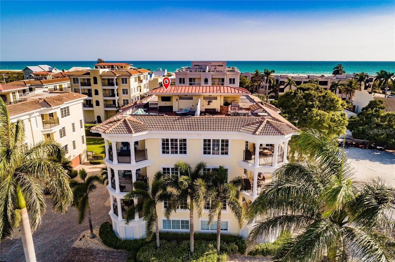 Experience exceptional Siesta Key living in this distinctive two-level penthouse, crowned by an expansive private rooftop terrace with Gulf glimpses, spectacular sunsets and refreshing coastal breezes. Ideally situated in the heart of Siesta Village, just a short stroll from the world-renowned sands of Siesta Beach, this turnkey furnished residence offers 3,236 square feet of beautifully appointed living space, four bedrooms, four baths and multiple private outdoor terraces. The rooftop terrace is a true highlight, creating an extraordinary setting for sunset gatherings, entertaining under the stars or simply relaxing above the vibrant Village atmosphere. Inside, spacious open-concept living areas are designed for comfort and entertaining, complemented by a well-appointed kitchen with a generous center island, breakfast bar and seamless access to outdoor terraces. A separate entertainment room features a wet bar and expansive terrace, providing additional space for family and guests. The inviting primary suite offers a private terrace and spacious bath with soaking tub and walk-in shower, while a second en-suite bedroom and two additional guest bedrooms provide comfortable accommodations. A private elevator connects the oversized attached two-car garage to the living levels, offering convenience and ample storage for beach and recreational gear. Within an intimate, gated community of just 12 residences in three four-unit buildings, each building enjoys its heated pool and spa. Offered turnkey furnished for immediate enjoyment, this exceptional penthouse places the boutiques, restaurants and lively atmosphere of Siesta Village nearby, with Siesta Beach an easy distance from home. Whether enjoyed as a full-time residence, luxurious island retreat or vacation property with rental potential, subject to community restrictions, this remarkable offering combines generous living spaces, exceptional outdoor retreats and one of Siesta Key's desirable locations.