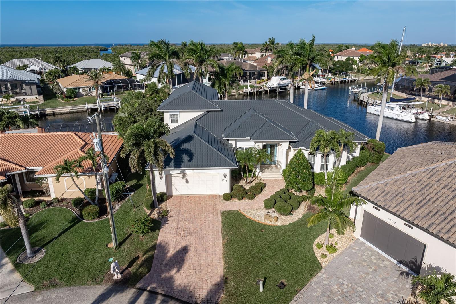CUSTOM, TIP-LOT, FERO BUILT WATERFRONT HOME IN PGI WITH **NEW ROOF**, 163 FT OF SEAWALL & VERY QUICK SAILBOAT ACCESS - Here, life revolves around the water. From morning coffee overlooking intersecting canals to afternoons on the golf course and evenings spent cruising toward open water, this 5 bed/3.5 bath, Punta Gorda Isles tip-lot home offers the kind of lifestyle many come to Southwest Florida to find. With quick sailboat access to Charlotte Harbor via Ponce Outlet, some of the region’s best boating and fishing awaits right from your backyard. The home has been meticulously maintained throughout the years by the owner was by a retired Naval Engineer who late became a builder who was the winner of a national "builder of the year" award. The home was thoughtfully designed to maximize the footprint of the lot while keeping the water in view from nearly every room. Inside, the layout supports both entertaining and everyday living. A formal living room with high ceilings, crown molding, and a gas fireplace sets a welcoming tone, while a separate family room provides a relaxed space to gather after a day on the water or the course. The centrally located kitchen anchors the home and is designed for those who enjoy hosting. A 5-burner GE Monogram gas range, built-in double ovens, two raised dishwashers, a wine refrigerator, a large center island, and generous cabinet and counter space make it easy to entertain family and friends. The first-floor master suite is a true owners' retreat, complete with a den, home office, and two oversized walk-in closets. Two guest bedrooms on the main level share a jack-and-jill bathroom. Laundry room doubles as a walk-in pantry or storage room with tons of storage space. While upstairs, two additional guest bedrooms share a hall bath. One of the upstairs bedrooms enjoys a beautiful canal view and works equally well as a home office, studio, or flex space. Outdoor living is where this home truly shines. A screened lanai with a two-tier deck overlooks the water and features a heated pool with an attached spa and water feature. Northwest rear exposure brings comfortable afternoon light and colorful sunset skies. With 163 feet of seawall and two docks at either end of the tip lot, you can keep multiple boats docked in back without sacrificing your canal view, Fishing trips or long days exploring Charlotte Harbor and the Gulf beyond are calling you. Recent improvements include a NEW stone-coated metal tile roof completed in December 2025 & NEW garbage disposal (2025). Other amenities include three A/C systems, an attached two-car garage with additional storage space, an interior laundry room with more storage space plus whole-house hurricane protection with electric and roll-down shutters, and a 50-gallon high-capacity Rheem water heater. The home has been meticulously maintained and is ready for immediate enjoyment. Although known for its boating, Punta Gorda also boasts a robust music and art scene with numerous festivals and fairs held throughout the year. Living in Punta Gorda Isles allows for optional membership in the PGI Civic Association with no mandatory HOA. Join and get connected with neighbors who share your interests with many different clubs and group activities. You'll also enjoy close proximity to St. Andrews South Golf Course, Fishermen’s Village, marinas, and waterfront dining. New roof was of the highest quality. Make an appointment today.
