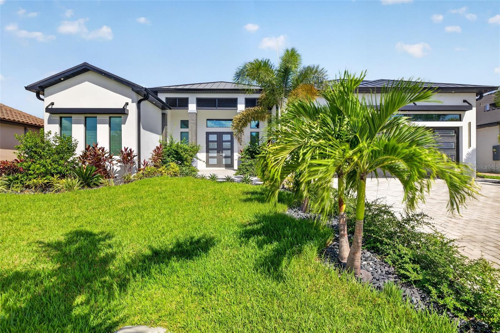 Welcome to an extraordinary waterfront retreat where luxury, craftsmanship, and the ultimate Southwest Florida lifestyle come together. This stunning NEW CONSTRUCTION residence offers 3,019 sq. ft. of impeccably designed living space, featuring 4 bedrooms PLUS a den, 3.5 baths, and an impressive 3-car garage with additional covered parking. Did I mention, NO FLOOD INSURANCE NEEDED?! From the moment you enter, exceptional quality is evident throughout. The open floor plan showcases soaring tray and coffered ceilings, elegant porcelain tile and luxury vinyl flooring, impact glass windows and doors, and premium finishes selected with both style and durability in mind. A whole-home generator, spray-foam insulation, metal roof, tankless water heater, and PGT impact windows provide an exceptional combination of comfort, efficiency, and peace of mind. At the heart of the home is a true chef's kitchen, featuring commercial-grade Jenn-Air appliances, a spectacular 48-inch dual-fuel gas range, pot filler, custom cabinetry, and a spacious walk-in butler's pantry. Designed for both everyday living and impressive entertaining, this kitchen is as functional as it is beautiful. The split-bedroom floor plan offers privacy and flexibility, while the dedicated den provides the perfect space for a home office, media room, or additional retreat. The luxurious primary suite features an elegant bath with dual vanities, soaking tub, separate shower, and generous walk-in closet. Step outside and discover your own private resort. The expansive outdoor living area features a heated pool and spa, outdoor kitchen and grill, outdoor shower, screened lanai, and breathtaking canal views. Just beyond the pool, your private waterfront setup awaits with a new Williamson Bros. dock, captain's walk, 16,000-lb. boat lift, and tiki bar—creating the perfect setting for boating, entertaining, sunset cocktails, and endless Florida days. With Gulf-access canal frontage, a private seawall, no HOA, and a location in one of Cape Coral's most desirable areas, this exceptional property offers the rare opportunity to enjoy a brand-new luxury home with an uncompromising level of detail. This is more than a home—it is the Southwest Florida lifestyle you've been waiting for. Come experience it for yourself.