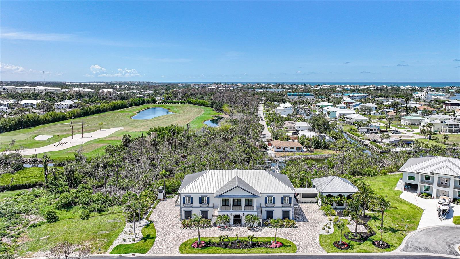 Spanning over 4,460 SQFT under air, this 3-bedroom, 3.5-bathroom masterpiece features a 6-CAR GARAGE divided between east and west wings, a PRIVATE ELEVATOR and impeccable craftsmanship in every detail. Built in 2017 and thoughtfully updated with high-end upgrades, new interior and exterior paint, and enhanced features throughout, this home offers a rare combination of elegance, functionality, and resort-style living. The home's stately curb appeal includes a tri-colored paver driveway, lush landscaping, and a grand double staircase leading to an impressive front balcony. At the heart of the home, a chef’s kitchen is outfitted with rich cabinetry, granite countertops, designer tile backsplash, a gas cooktop, and premium WOLF appliances. A large center island anchors the space, while an adjacent built-in bar enhances functionality for entertaining. With seamless access to two fully equipped outdoor kitchens and multiple balconies, the home is perfectly designed for indoor-outdoor living. The expansive primary suite serves as a luxurious retreat with wraparound balconies, tray ceilings, an electric fireplace, and a custom dressing area with a built-in vanity. The spa-like ensuite bath features a soaking tub, glass-enclosed shower with designer tile, dual vanities, and a private water closet. Each guest bedroom is ensuite and includes custom closets and high-end finishes.  A unique architectural breezeway leads to the private indoor/outdoor pool and pool house. This serene retreat is enclosed by arched screened windows to allow natural coastal breezes and features new lighting, updated pool equipment, elegant paver decking, and a coffered ceiling with fans. Whether hosting guests or enjoying a quiet afternoon, this resort-style space offers year-round comfort and style.  For boating enthusiasts, a newly constructed private dock provides quick access to Lemon Bay and Stump Pass. With 2 new boat lifts capable of handling up to a 40' offshore boat and a second lift which lifts a 20' inshore boat easily.  This luxury home is geared toward fisherman enthusiasts being 1.6 miles to Stump Pass and only 4.7 miles to Boca Grande which is a gateway to World Class tarpon fishing. In addition, Key West is a mere 145 miles by boat!
Additional highlights of this exceptional home include a brand-new security camera system, pre-stressed concrete floors throughout (extending to the balconies), impact windows and doors, a durable metal roof, a home gym/flex room, custom millwork and ceiling treatments, an EV charger, and a 60 kW whole-house generator. The professionally landscaped grounds are enhanced with irrigation and Lutron smart lighting systems. Experience the pinnacle of coastal luxury in this extraordinary waterfront residence, perfectly situated on two manicured lots within the prestigious, gated community of Lemon Bay Golf Club one of Florida’s most exclusive golf communities, this waterfront estate presents an unparalleled opportunity for those seeking refined living, unmatched privacy, and effortless access to coastal adventure. The Seller is pleased to offer an OWNER FINANCING option, this unique financing structure provides a streamlined alternative to traditional bank lending. Please call agent for details!